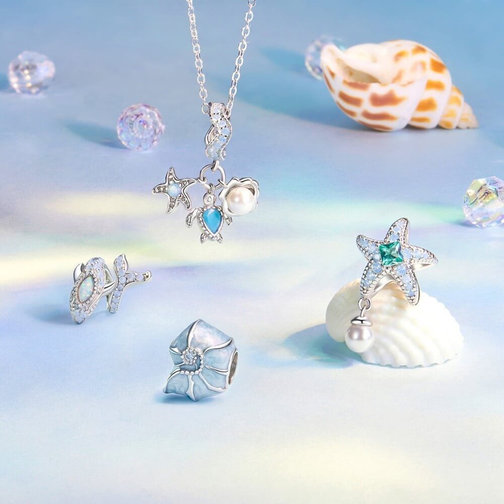 Sterling silver sea charm with turtle, pearl, and starfish details.