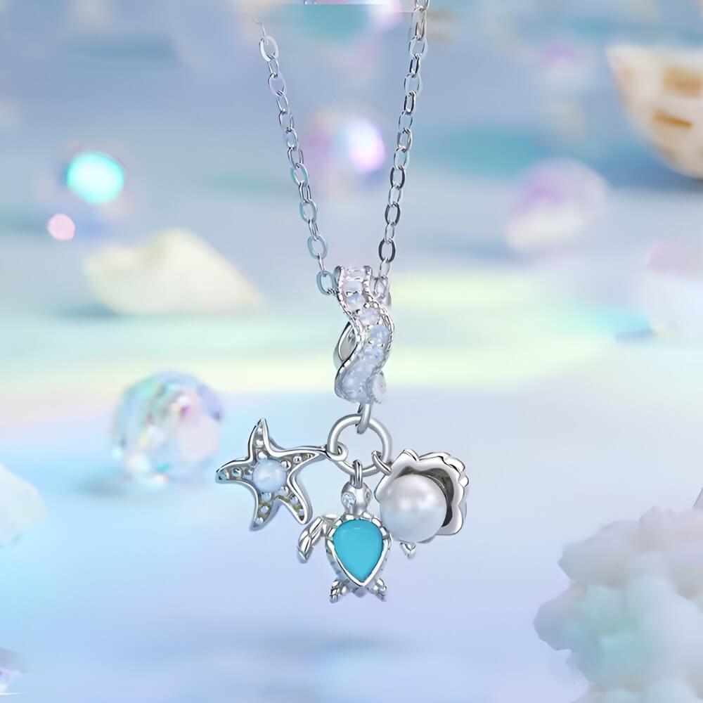 Sterling silver sea charm with turtle, pearl, and starfish details.