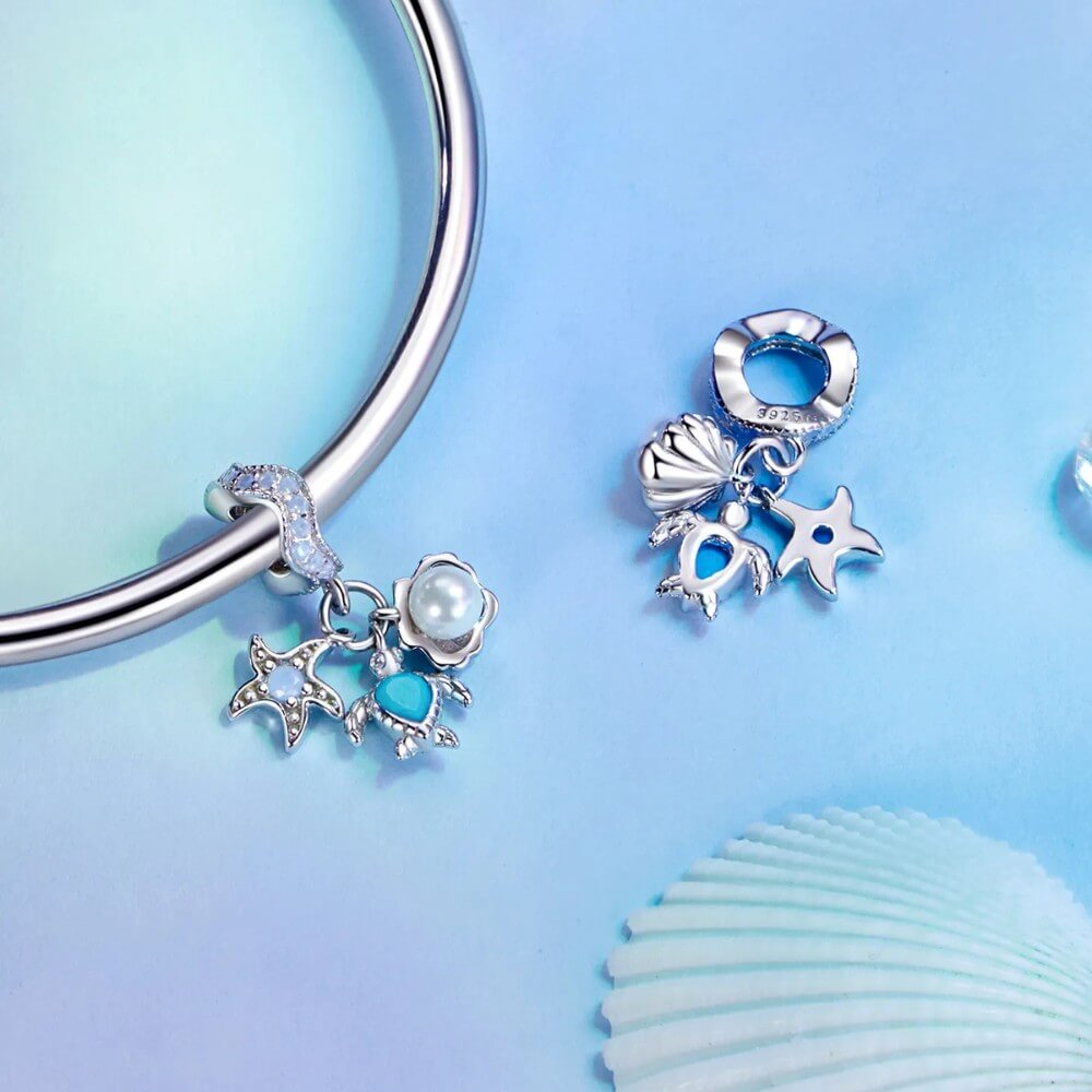 Sterling silver sea charm with turtle, pearl, and starfish details.