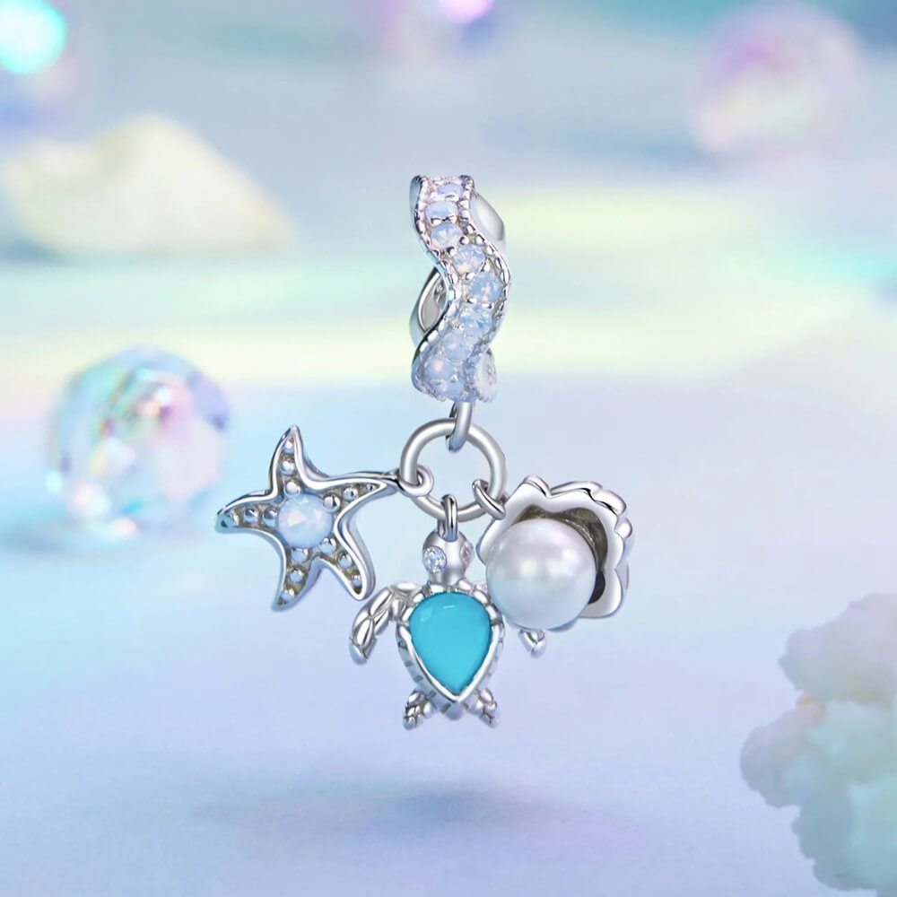 Sterling silver sea charm with turtle, pearl, and starfish details.