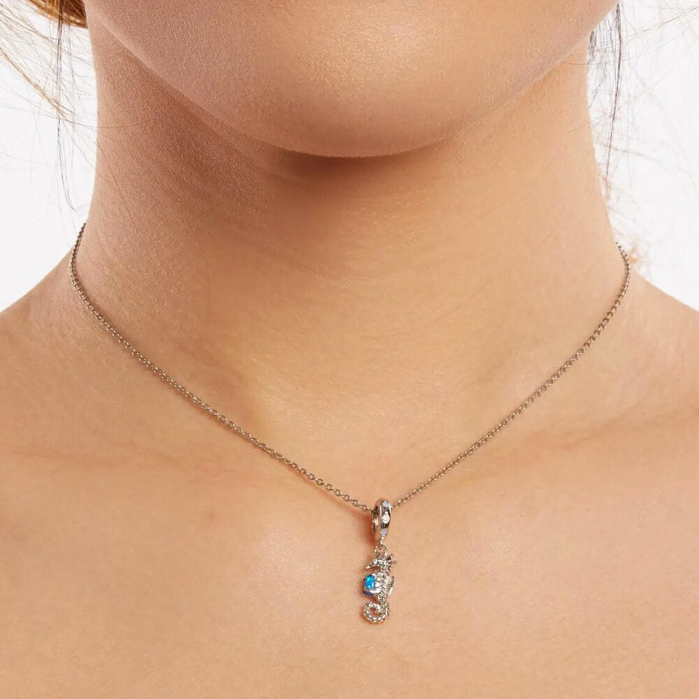 Sterling silver seahorse charm with blue opal and crystal accents.