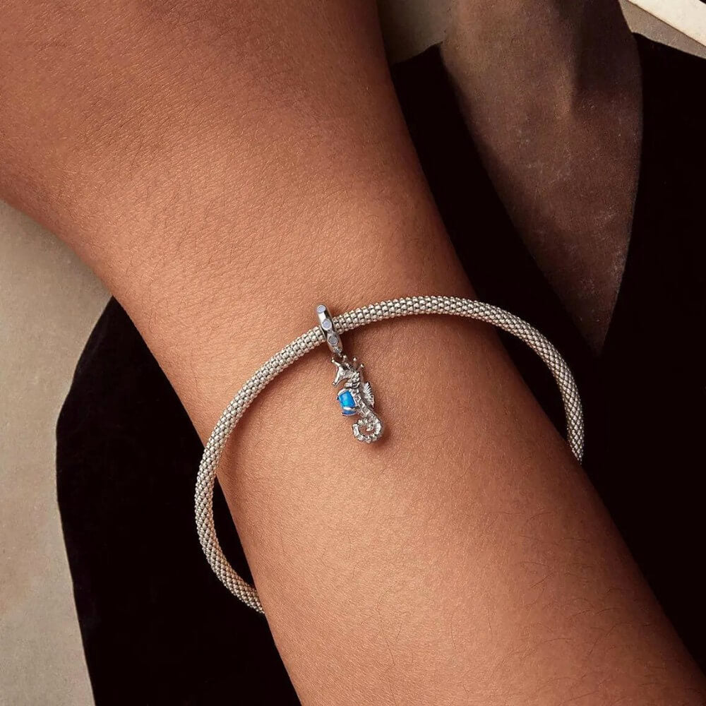 Sterling silver seahorse charm with blue opal and crystal accents.