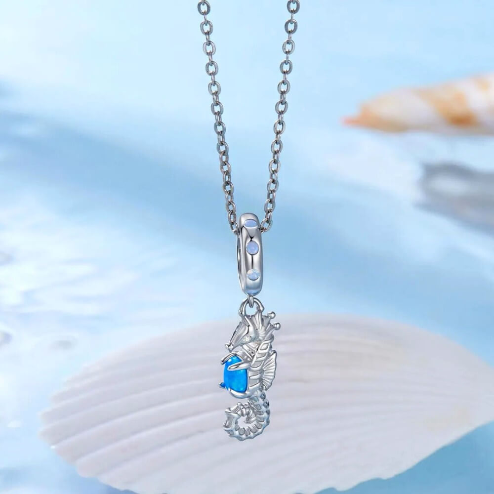 Sterling silver seahorse charm with blue opal and crystal accents.