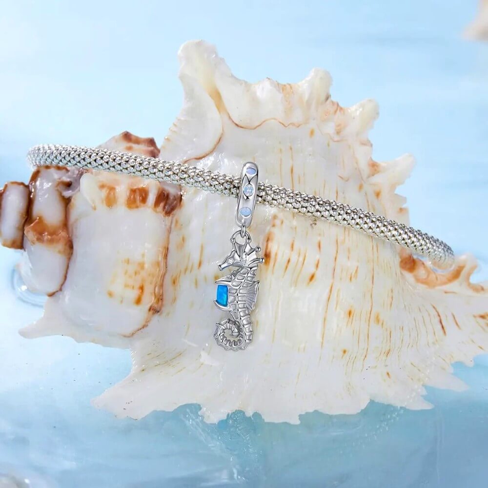 Sterling silver seahorse charm with blue opal and crystal accents.