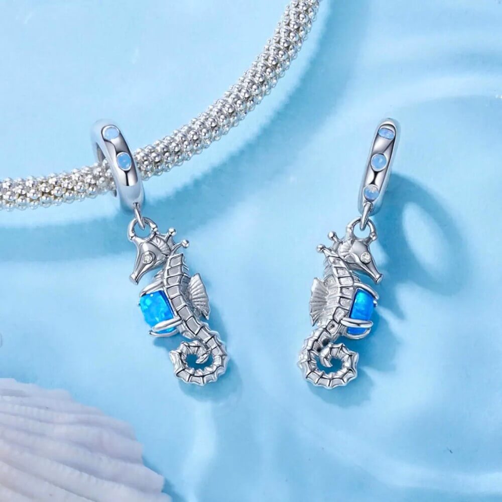 Sterling silver seahorse charm with blue opal and crystal accents.