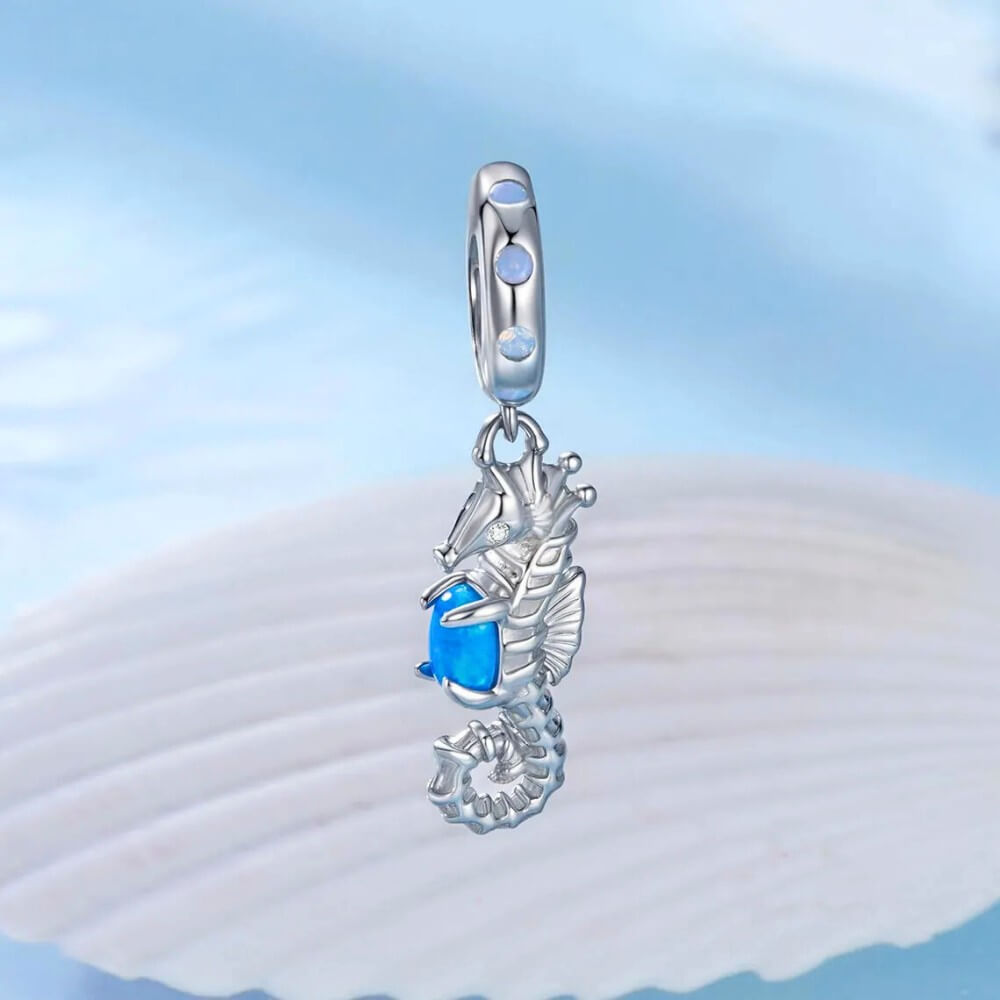 Sterling silver seahorse charm with blue opal and crystal accents.