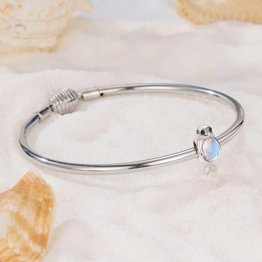 Sterling silver seal charm with iridescent opal belly and black enamel eyes.