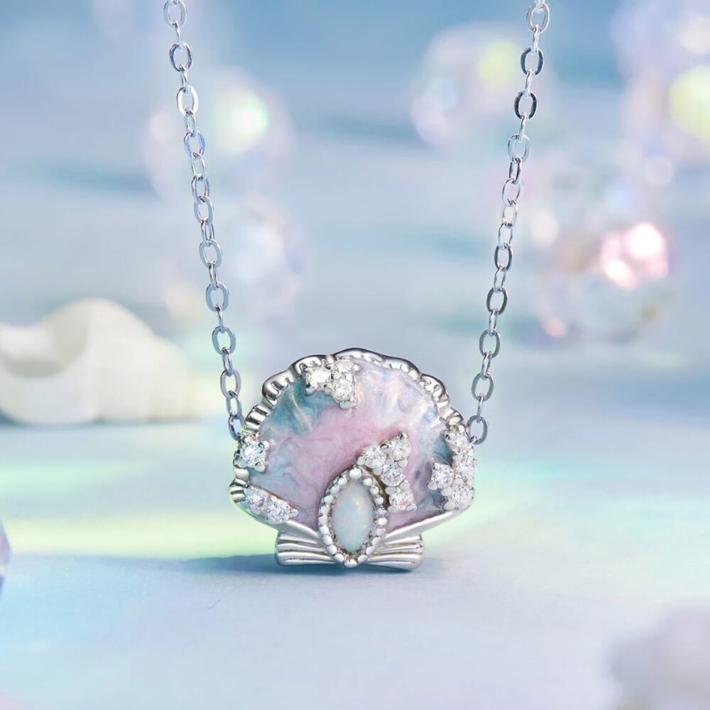 Sterling silver seashell charm with pastel enamel and crystal accents.