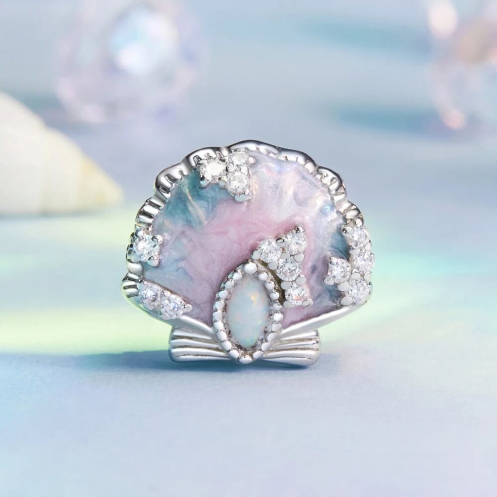 Sterling silver seashell charm with pastel enamel and crystal accents.