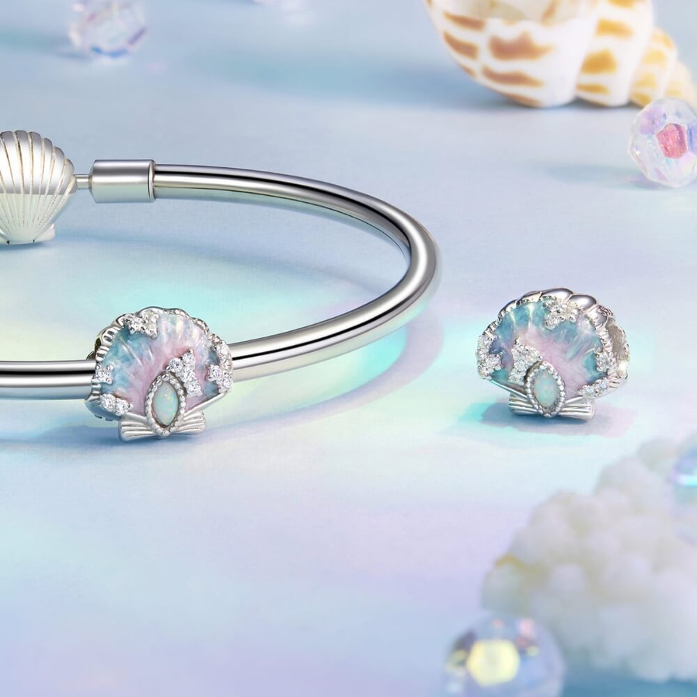 Sterling silver seashell charm with pastel enamel and crystal accents.