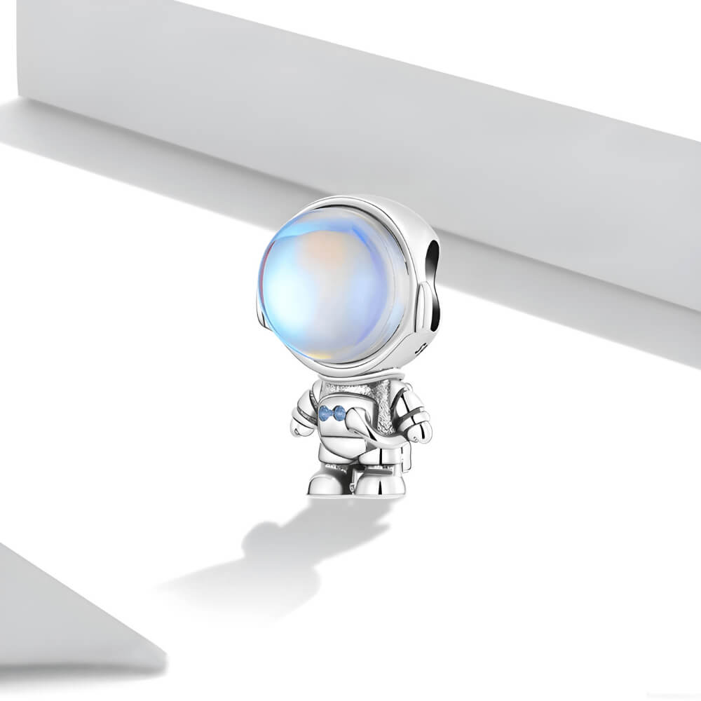 Sterling silver astronaut charm with a large iridescent glass helmet and small blue crystal details on the suit