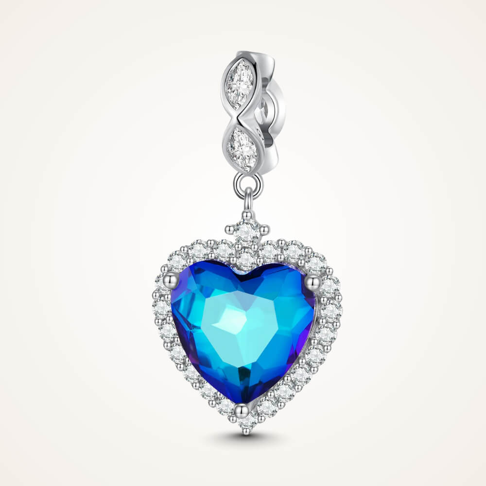 Sterling silver charm with a large faceted blue heart crystal framed by clear stones and a decorative bail set with clear marquise crystals – ORÉYA