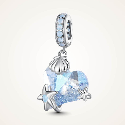 Sterling silver charm with a faceted blue heart crystal, silver seashell and starfish accents, and a bail set with light-blue stones – ORÉYA
