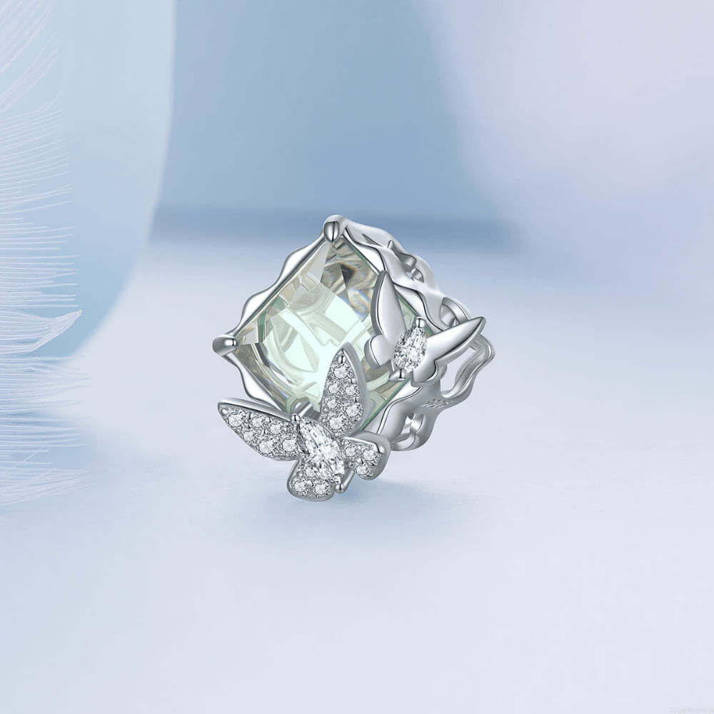 Sterling silver charm with a large pale green faceted stone and two crystal-studded silver butterflies on the front