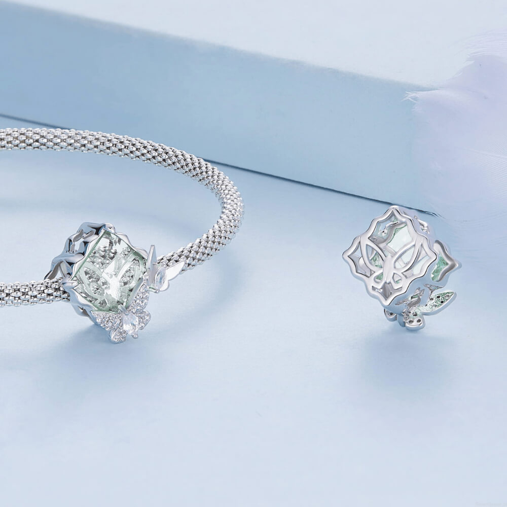 Sterling silver charm with a large pale green faceted stone and two crystal-studded silver butterflies on the front 