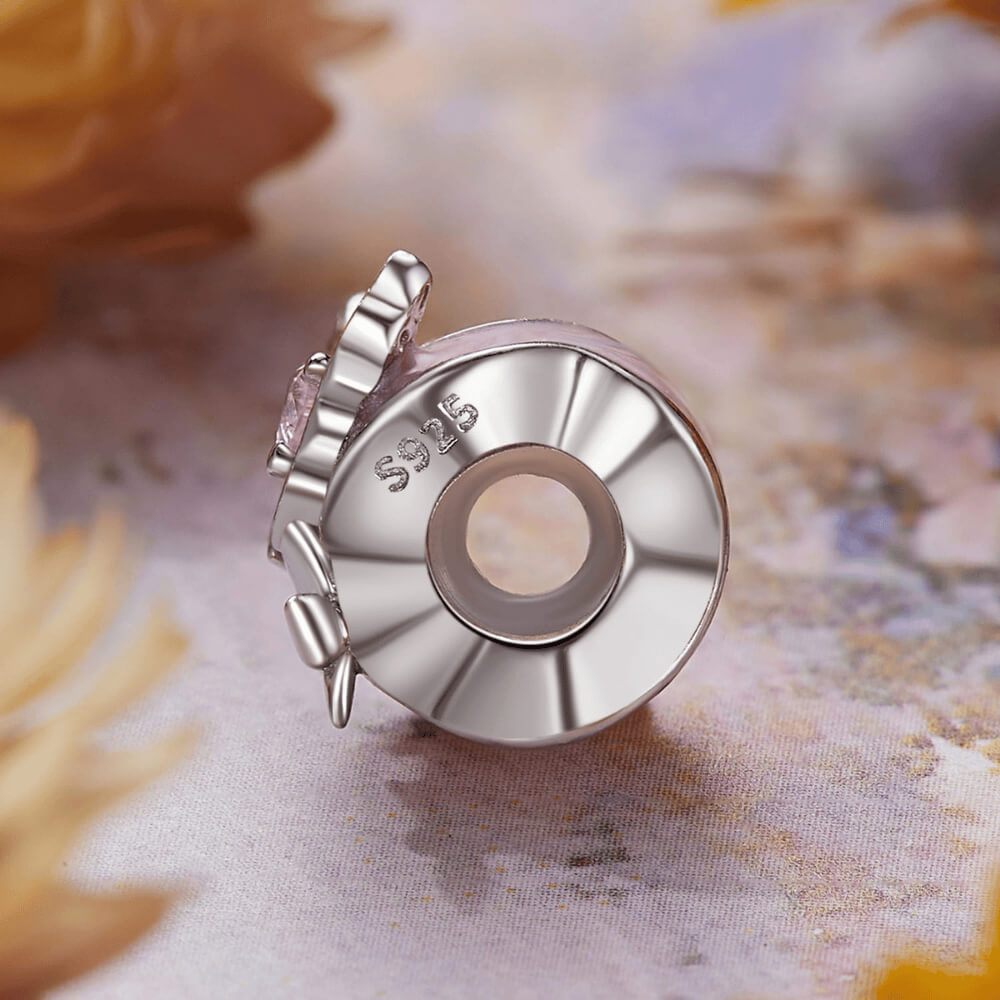 Sterling silver charm with a pale pink enamel background, a silver butterfly with a pink heart-shaped stone, and an additional silver flower detail