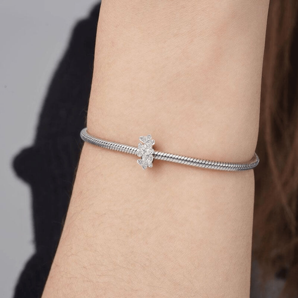 Sterling silver charm with three raised butterfly designs featuring detailed filigree wings