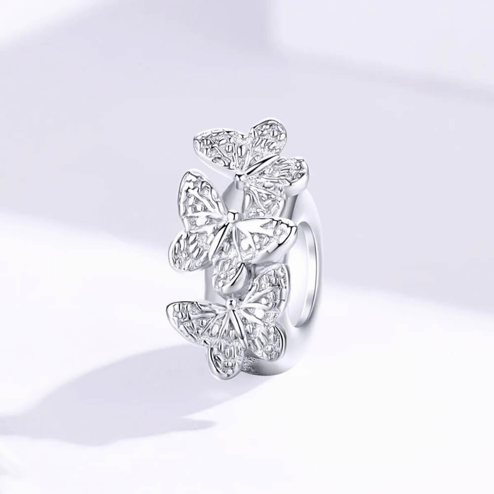 Sterling silver charm with three raised butterfly designs featuring detailed filigree wings 