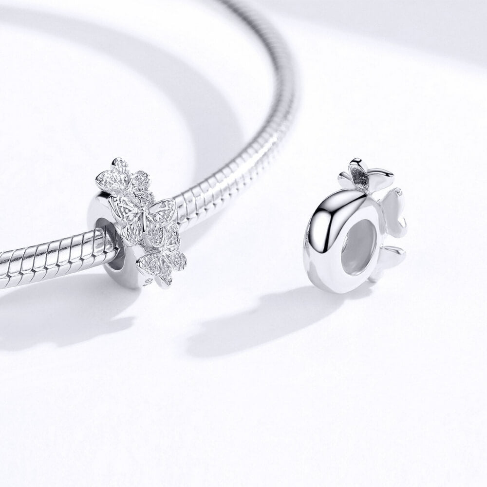 Sterling silver charm with three raised butterfly designs featuring detailed filigree wings