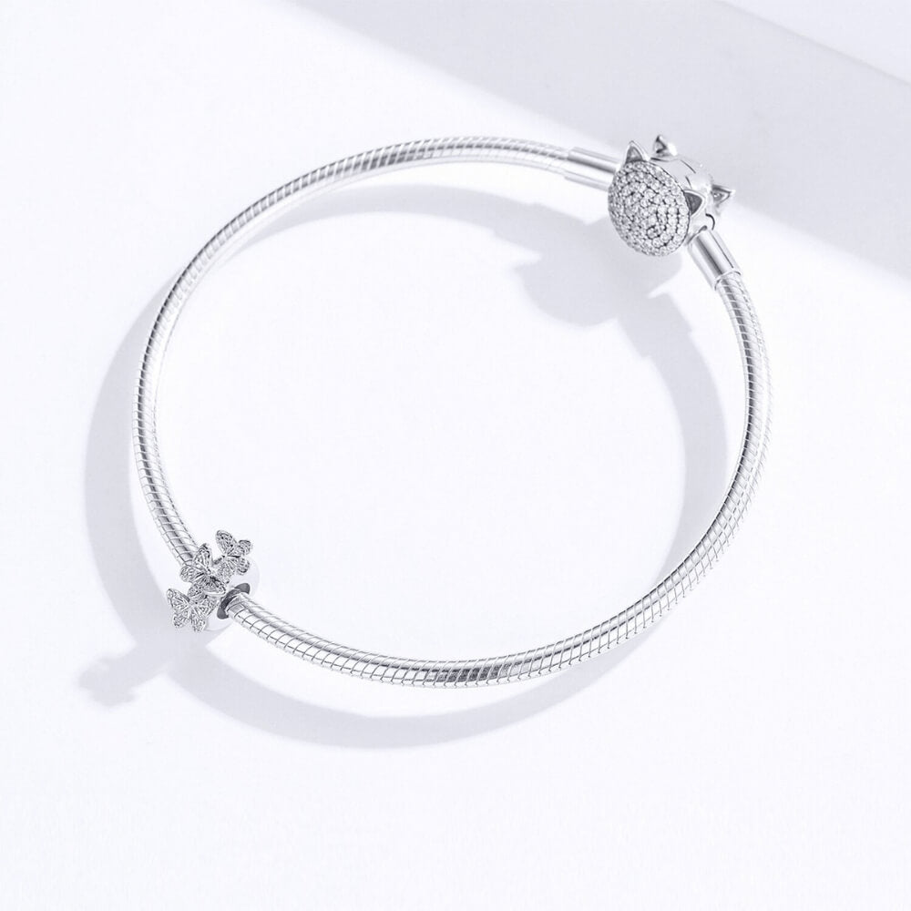 Sterling silver charm with three raised butterfly designs featuring detailed filigree wings 