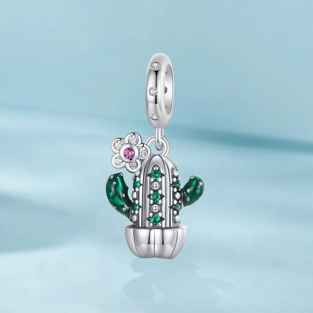 Sterling silver cactus charm with green enamel arms, green gemstones, and a small flower pendant with a pink crystal 