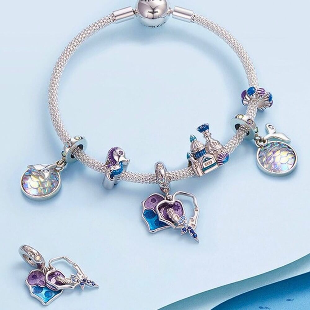Sterling silver castle charm with blue enamel domes, glitter details, and shell accent.
