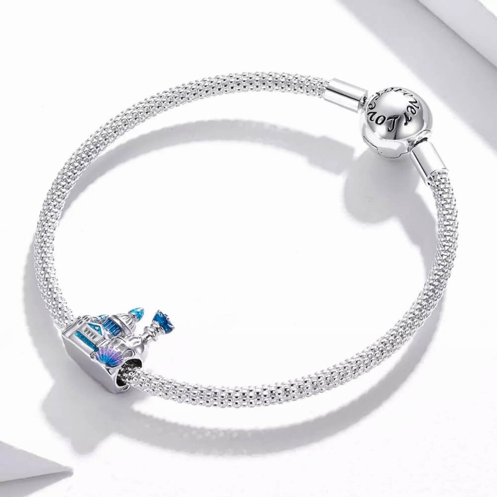 Sterling silver castle charm with blue enamel domes, glitter details, and shell accent.