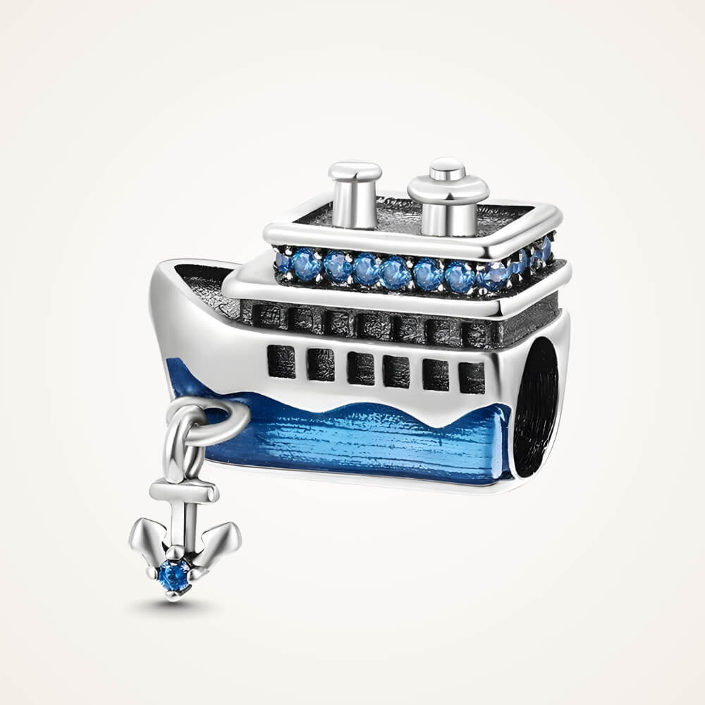 Sterling silver cruise-ship charm with blue enamel waves, blue crystal details on the upper deck, and a dangling anchor with a blue stone – ORÉYA