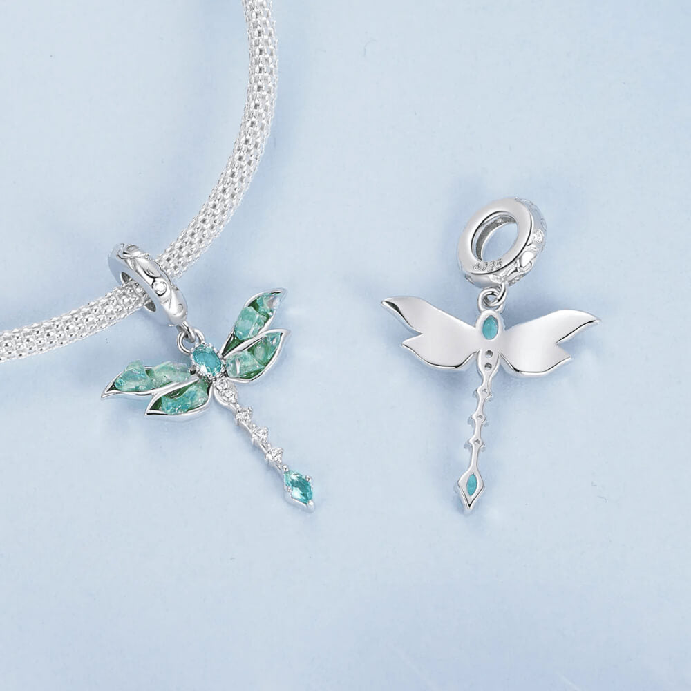 Sterling silver dragonfly charm with blue-green iridescent enamel wings, sparkling clear stones, and a teardrop blue crystal tail 
