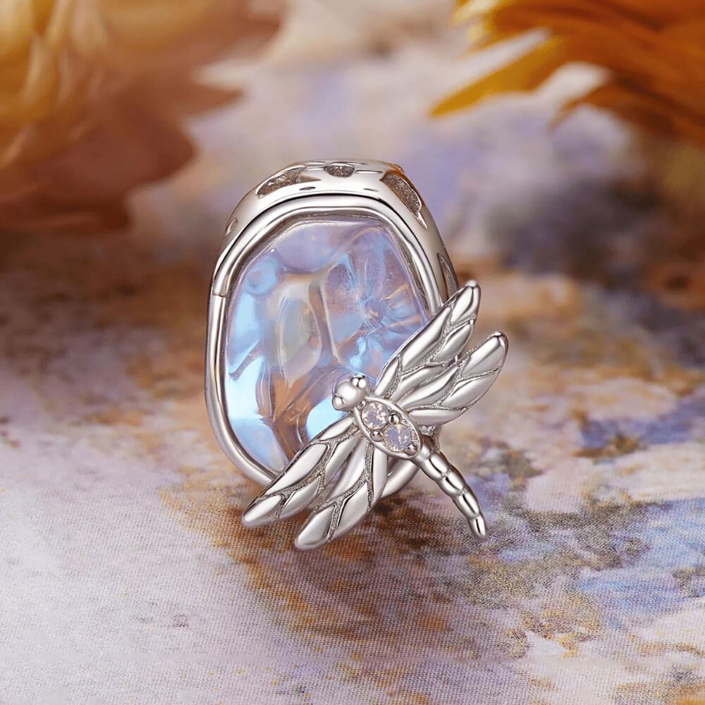 Sterling silver charm with an iridescent pastel glass stone and a silver dragonfly decorated with clear crystals 