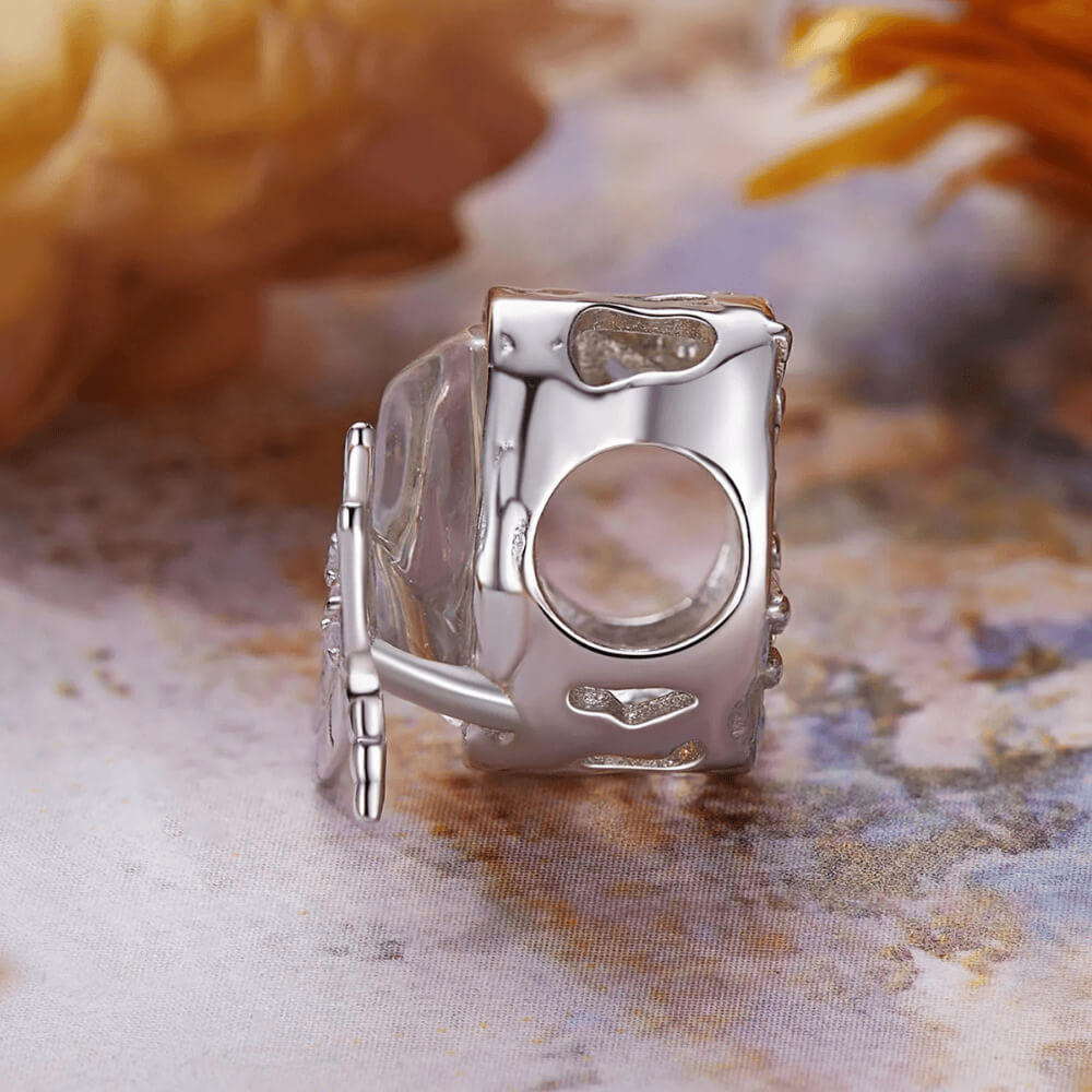 Sterling silver charm with an iridescent pastel glass stone and a silver dragonfly decorated with clear crystals 