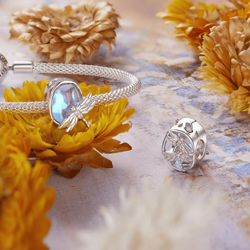 Sterling silver charm with an iridescent pastel glass stone and a silver dragonfly decorated with clear crystals 