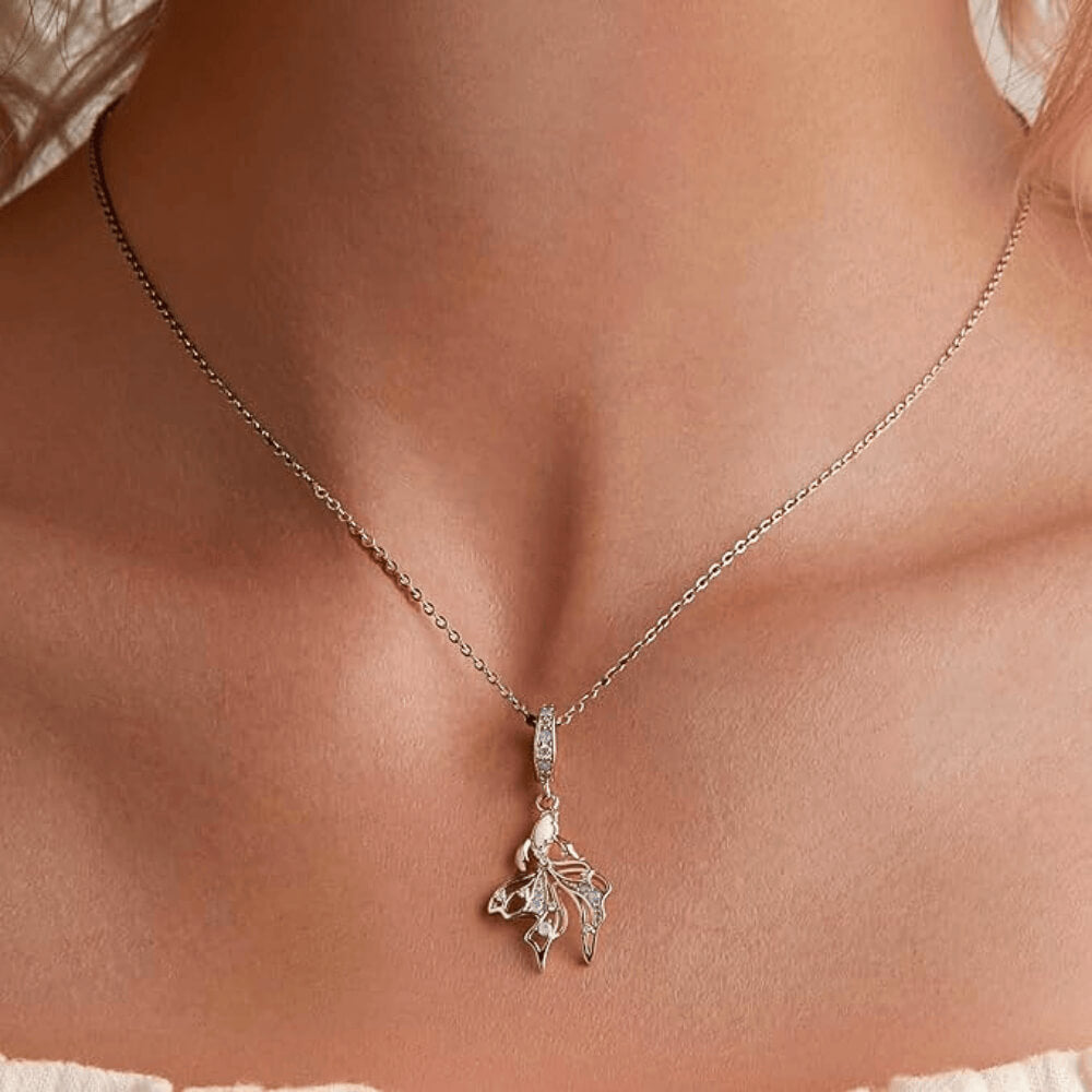 Sterling silver fish charm with opal-like stone and blue gemstone accents.