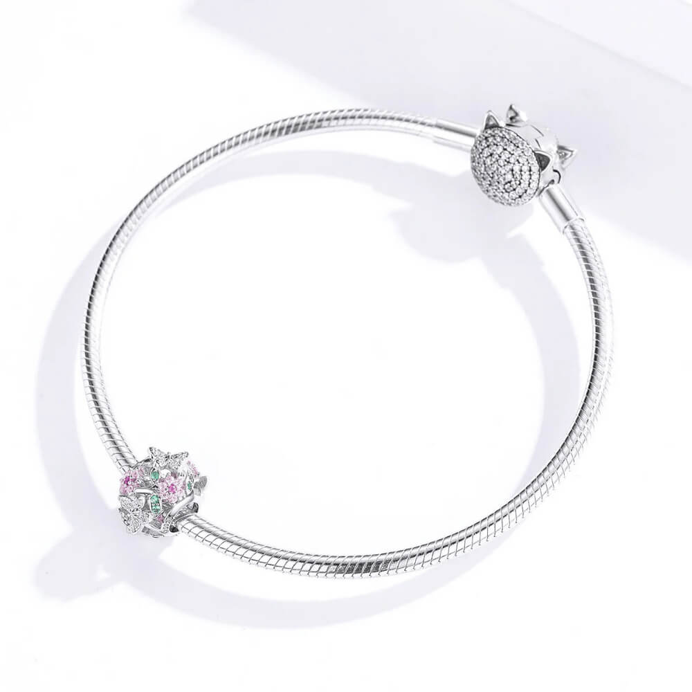Sterling silver openwork charm with pink crystal flowers, green crystal leaves, and silver butterflies with clear stones 