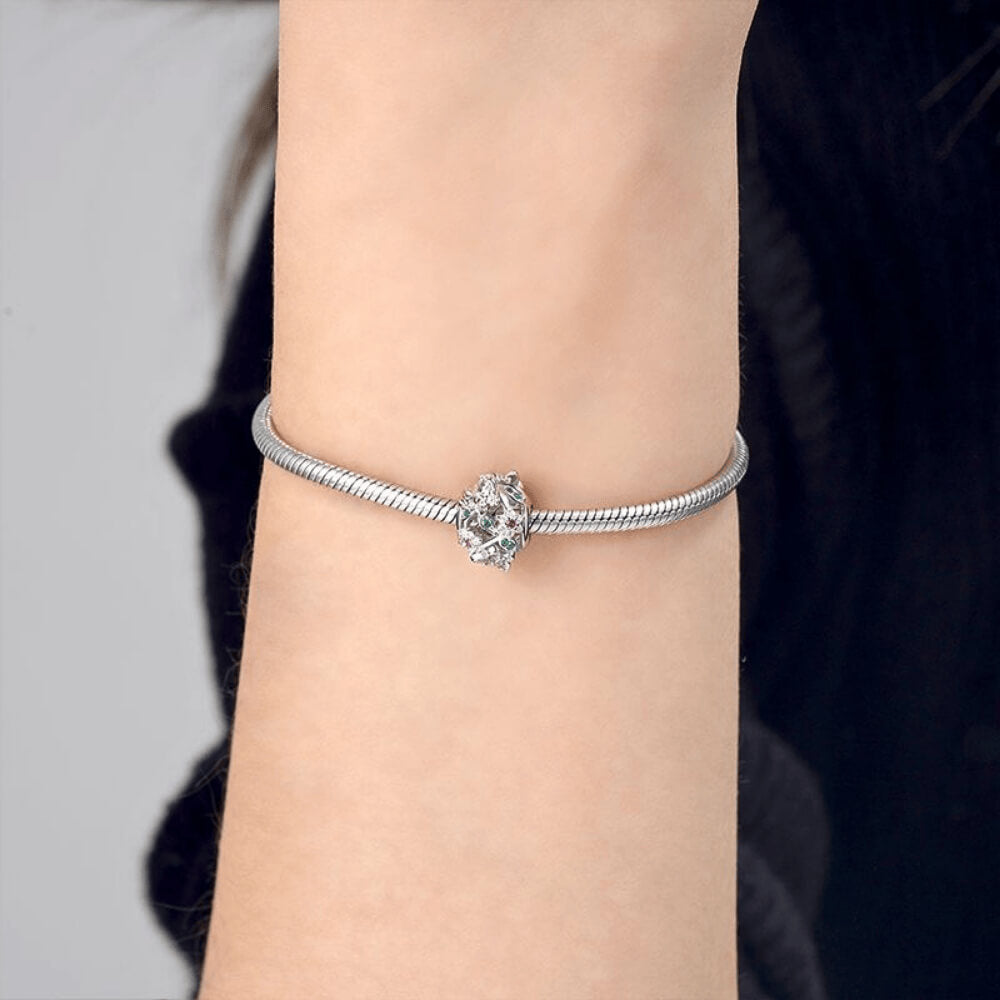 Sterling silver openwork charm with pink crystal flowers, green crystal leaves, and silver butterflies with clear stones 