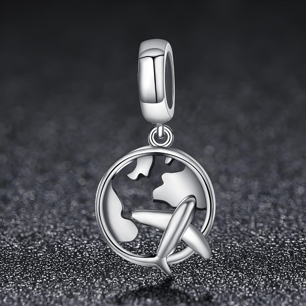 Sterling silver charm with a globe outline and a small airplane dangle in front 