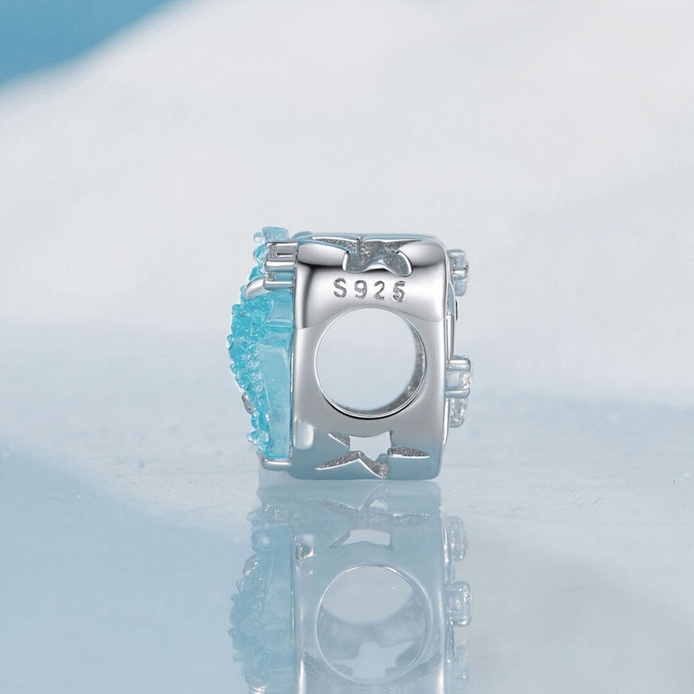 Sterling silver heart-shaped charm with a large blue crystal starfish, light-blue and clear stones, and an openwork background 