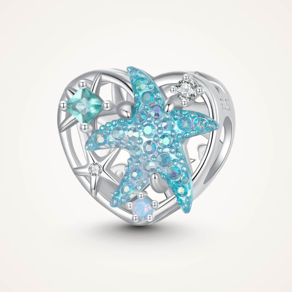 Sterling silver heart-shaped charm with a large blue crystal starfish, light-blue and clear stones, and an openwork background – ORÉYA