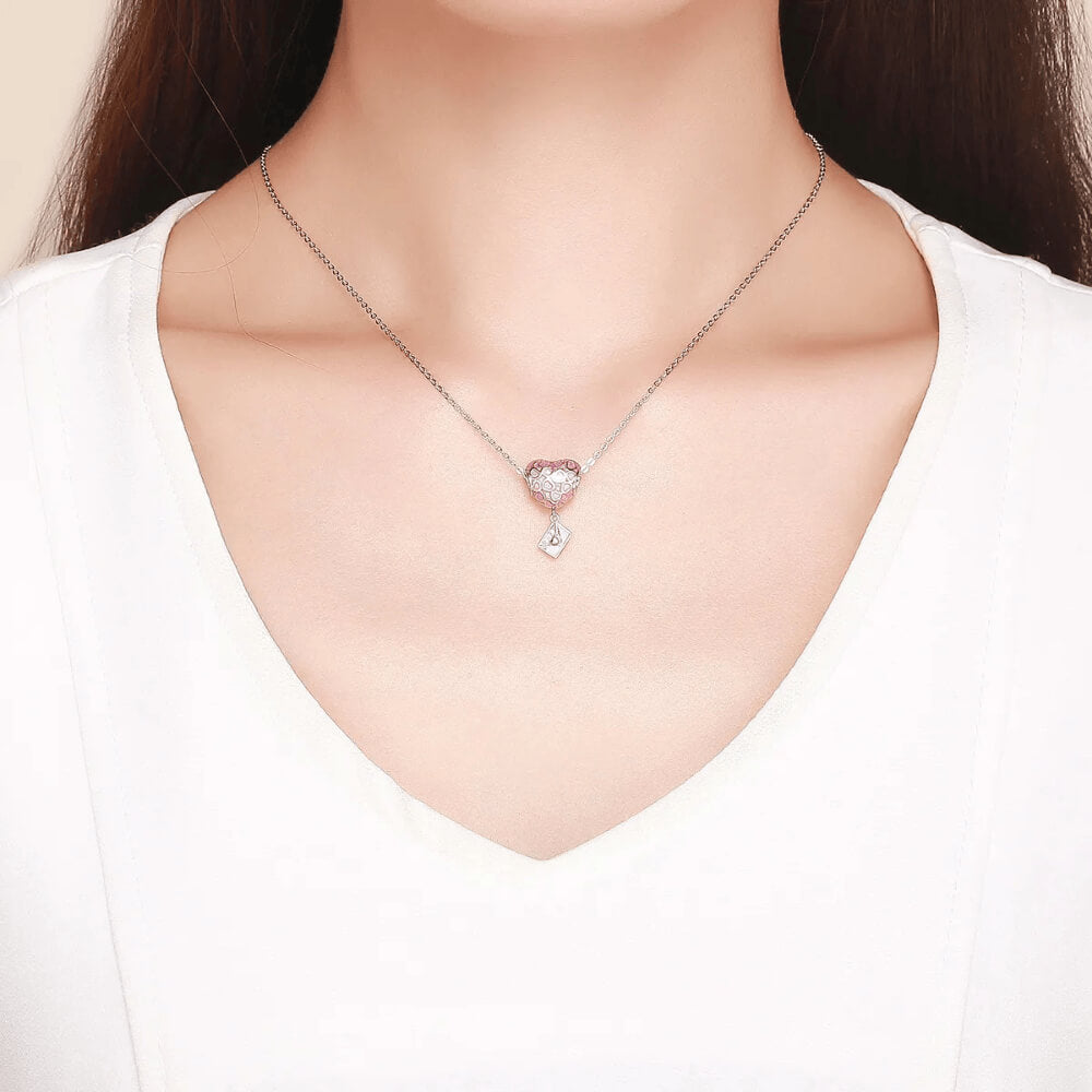 Sterling silver heart charm with pink enamel heart patterns and a dangling envelope accented with a small pink heart 