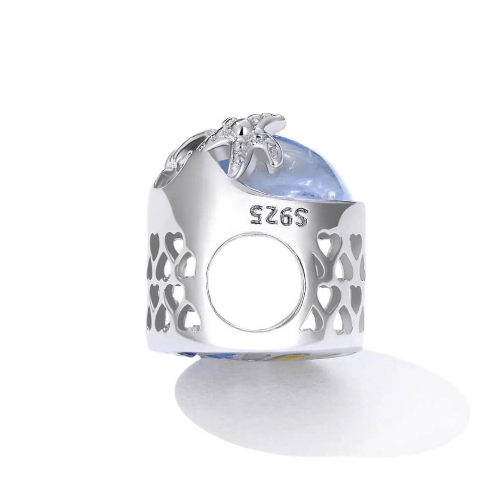 Sterling silver charm with an iridescent round glass center, featuring silver starfish and wave details on the surface