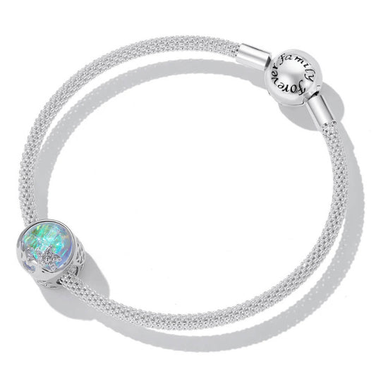 Sterling silver charm with an iridescent round glass center, featuring silver starfish and wave details on the surface 