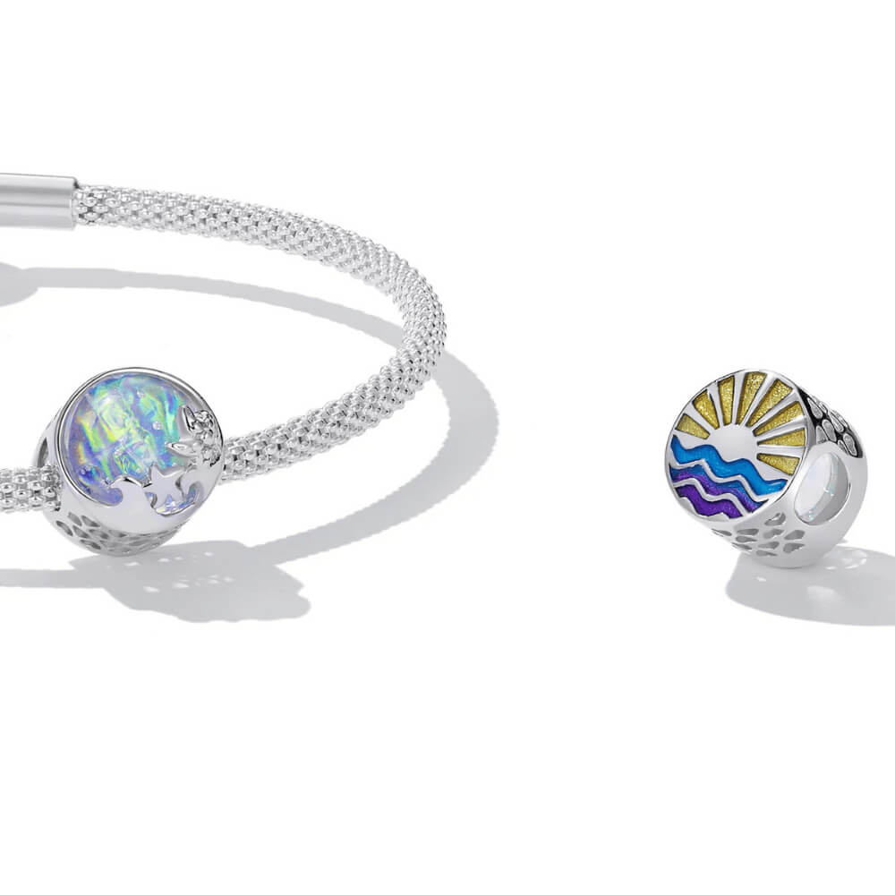 Sterling silver charm with an iridescent round glass center, featuring silver starfish and wave details on the surface 