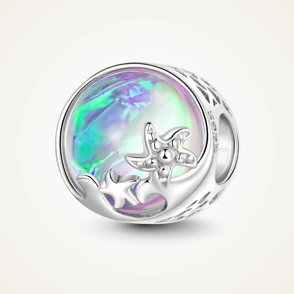 Sterling silver charm with an iridescent round glass center, featuring silver starfish and wave details on the surface – ORÉYA