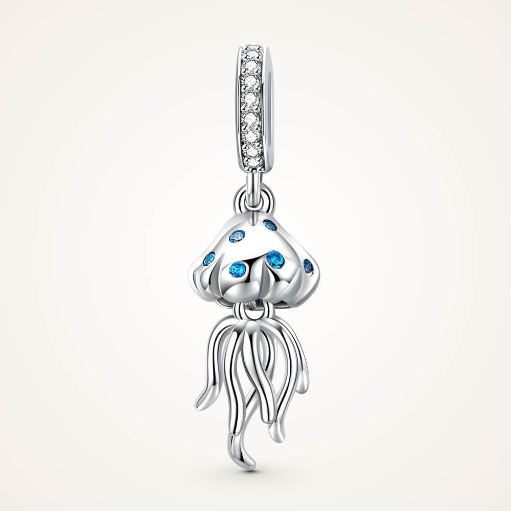 Sterling silver jellyfish charm with blue stones on the bell and long flowing tentacles, hanging from a bail set with clear crystals – ORÉYA