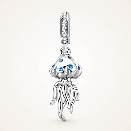 Sterling silver jellyfish charm with blue stones on the bell and long flowing tentacles, hanging from a bail set with clear crystals – ORÉYA