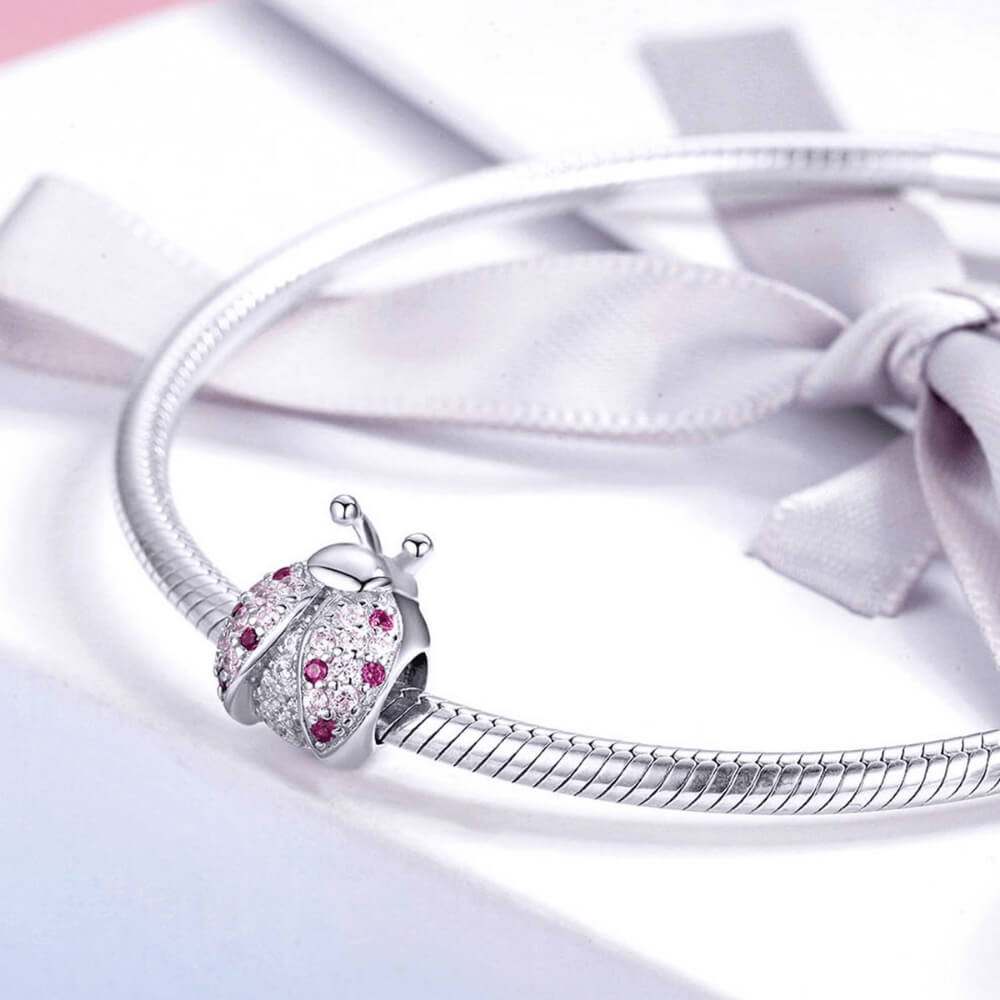 Sterling silver ladybug charm with pink and red crystals on the wings and clear stones on the body 