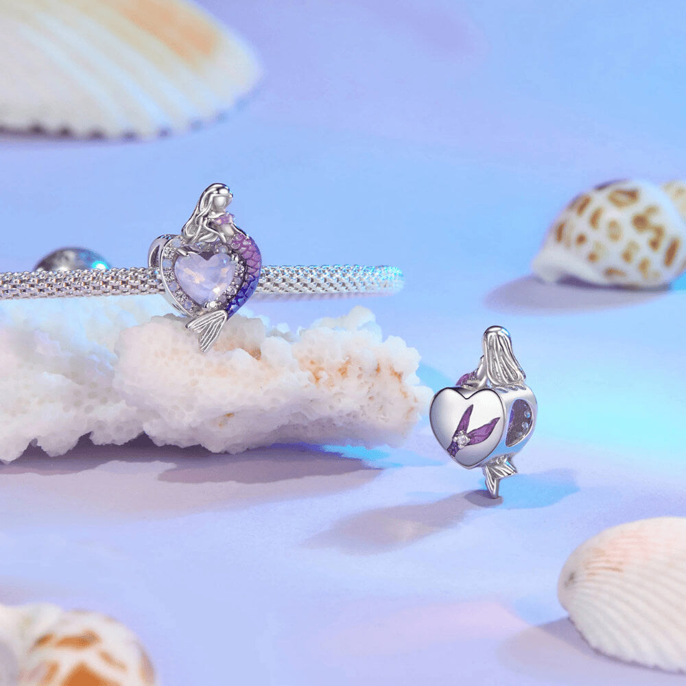 Sterling silver mermaid charm with a purple heart-shaped stone, crystal halo, and a gradient pink-to-blue enamel tail