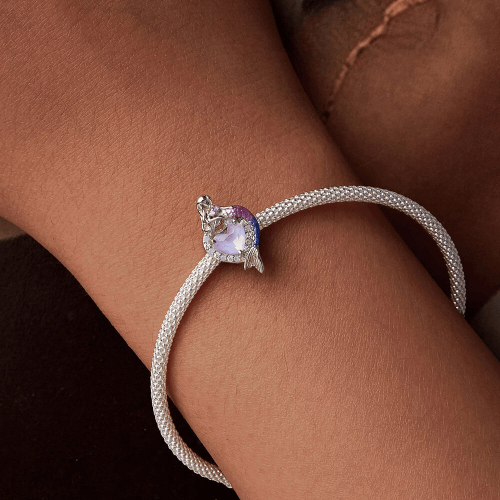 Sterling silver mermaid charm with a purple heart-shaped stone, crystal halo, and a gradient pink-to-blue enamel tail
