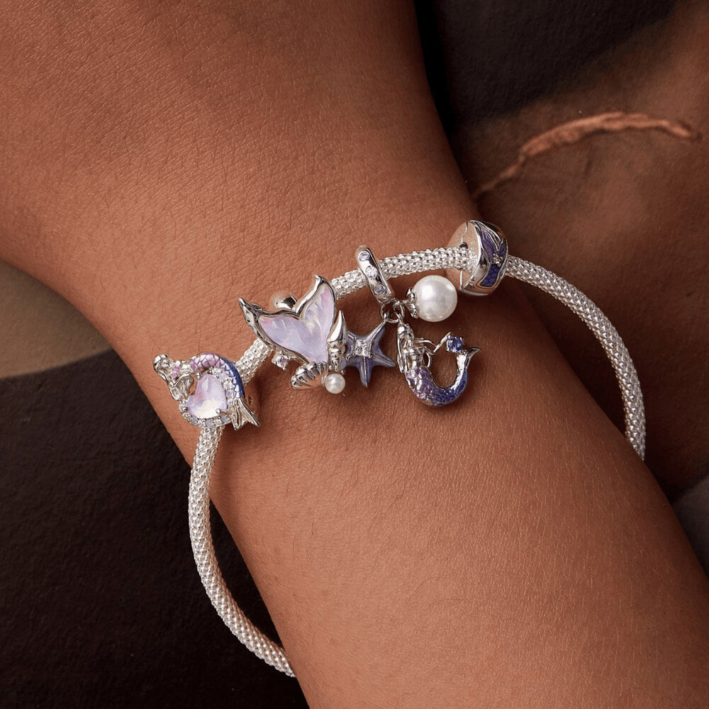 Sterling silver mermaid charm with a purple heart-shaped stone, crystal halo, and a gradient pink-to-blue enamel tail