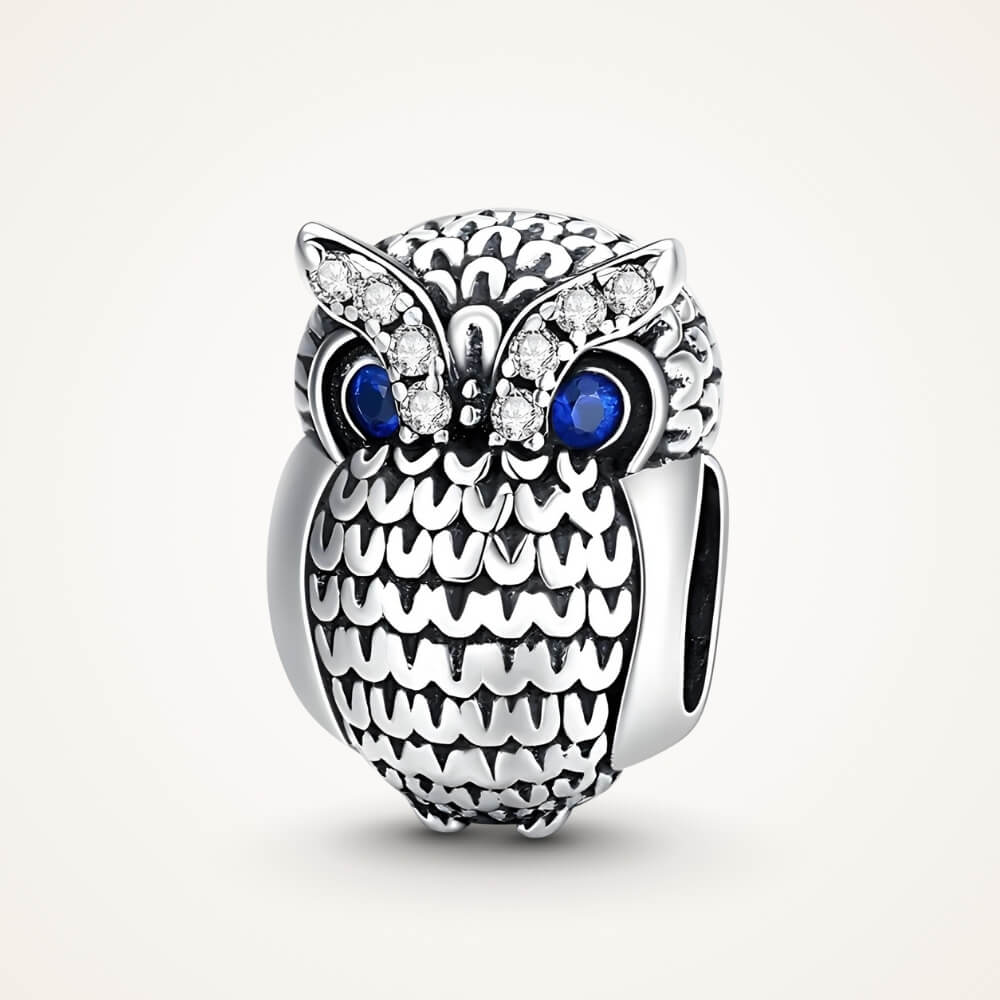 Sterling silver owl charm with textured feather design, blue eyes, and clear gemstones - ORÉYA
